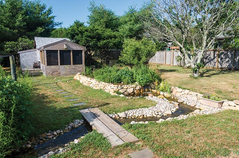 A man-made pond flows through the backyard.