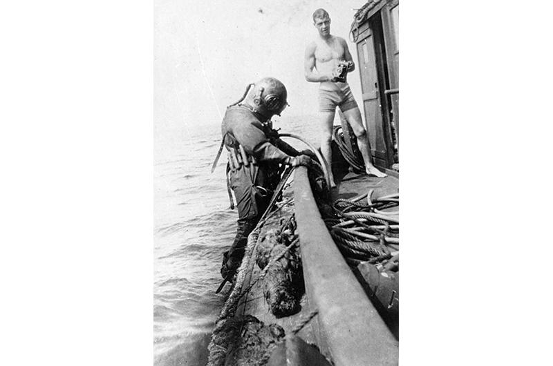 A professional salvage diver prepares to descend to the wreck, circa 1930.