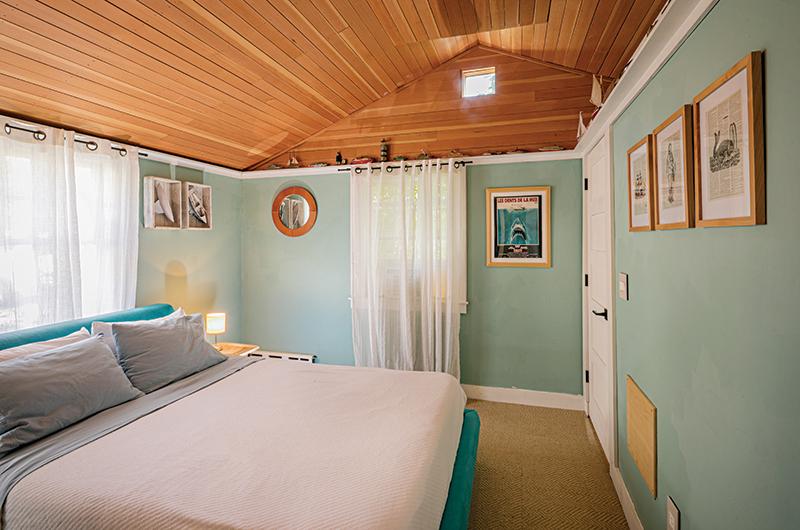 Nautical embellishments, such as a Jaws movie poster and a porthole-shaped mirror, give a fun nod to a beach house theme.