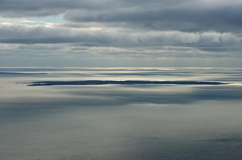 Cuttyhunk (foreground) and Noman’s Land flank the western tip of Martha’s Vineyard and the Gay Head Light.