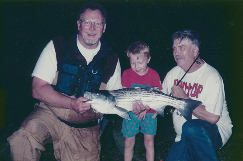 In 2000, less than a month after undergoing open-heart surgery, Coop (right) and Paul Fersen (left) helped Little Coop catch his first striped bass at Lobsterville Beach.