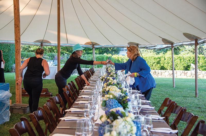 Hamlin (right) and Lily Morris set tables in preparation for a private fund-raising dinner in Edgartown.
