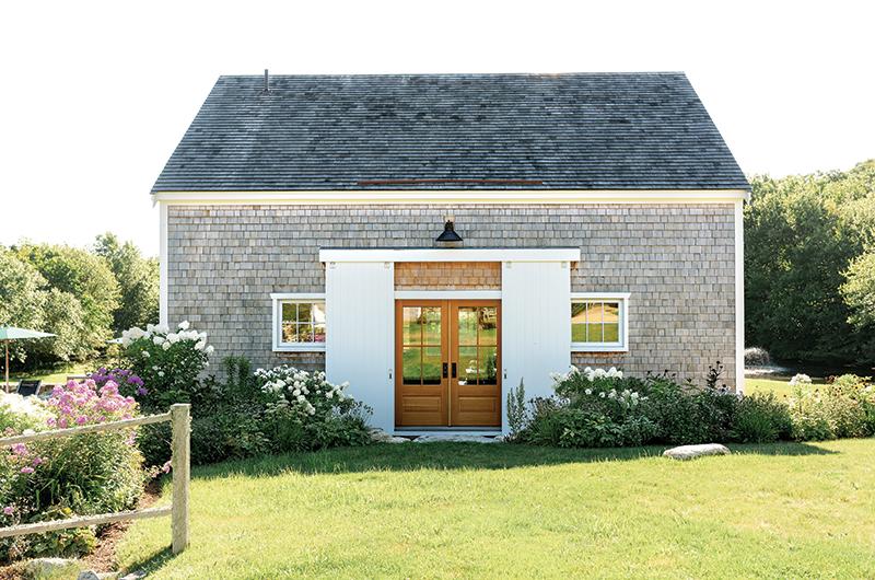 The new barn replicates the old one with an identical footprint and sliding white barn doors.