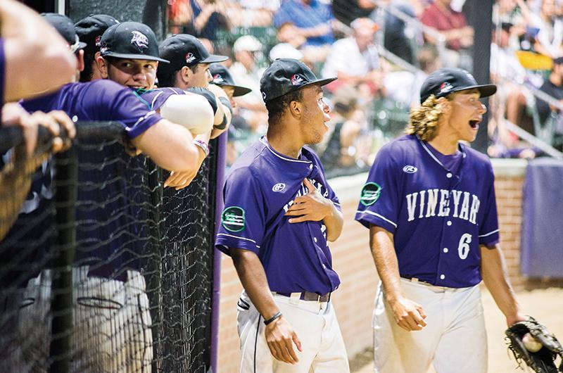 Josh Spiegel (in dugout), Kai Nelson, and Matt Chamberlain react to on-field action during the championship series at the Shark Tank in 2018.
