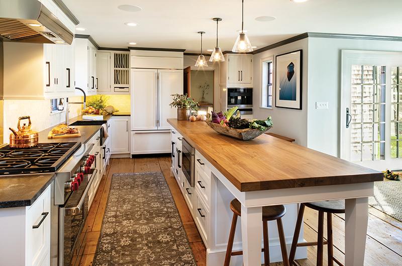Historic details are complemented by modern-day conveniences in the kitchen, part of the newer portion of the home. The flooring is made from wood planks that had been stored in the home’s rafters. Marshall Farm Wood-Works on Chappaquiddick handcrafted the stools.
