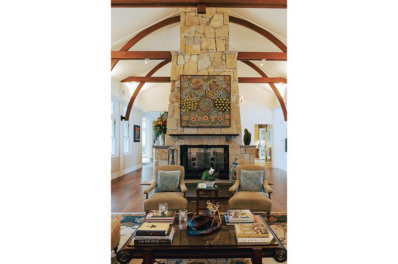 The living room features a double-sided fireplace and artwork curated by the couple.