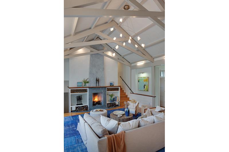 Scissor trusses along the ceiling and a single slab
of soapstone for the
fireplace add a modern twist to the living room.