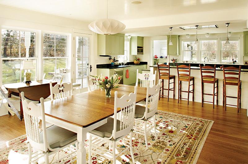 The dining room and kitchen area, part of the new addition at the back of the house, blends with the original architecture.