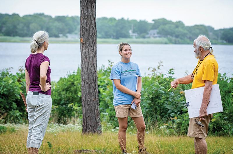 Angela Luckey (middle) meets with Oak Bluffs neighbors Sam Low (right) and Stephanie Mashek (left) to offer strategies for land use along Farm Pond and identify valuable plants on
Low’s land.