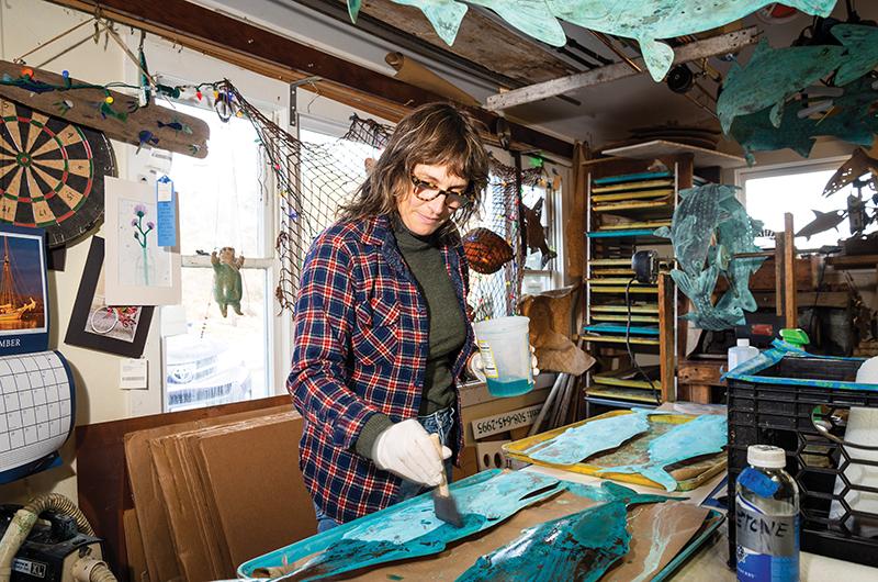 Annette Cingle applies a patina to the copper sculptures, creating an oxidized effect.