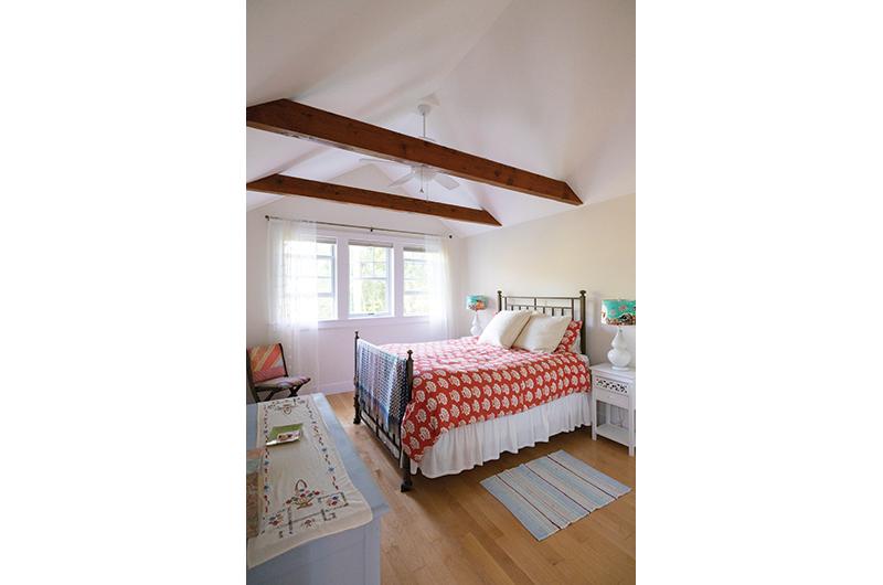 Original beams and yellow pine floors are a highlight in the master bedroom.