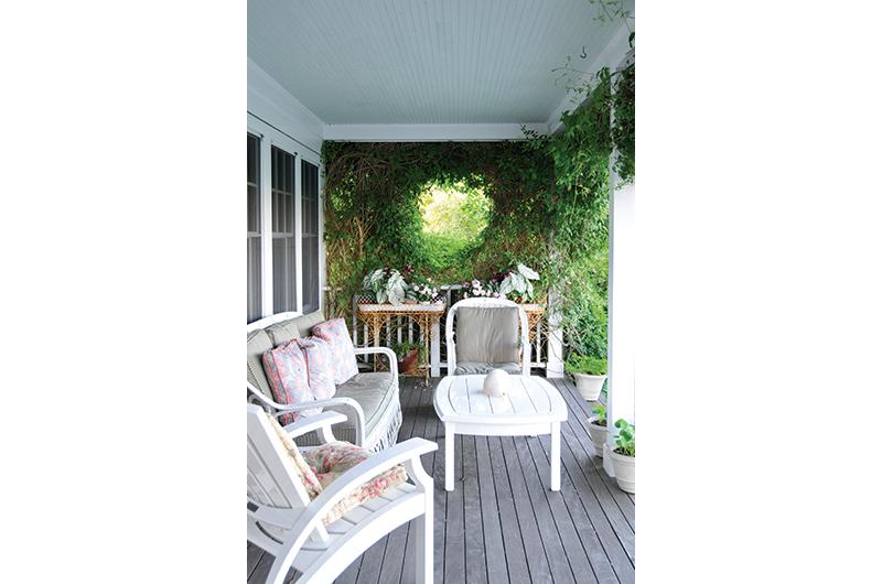 Clematis vines form a loosely woven heart at one end of the old-fashioned farmer’s porch.